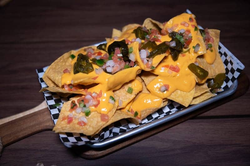 Nachos with cheese sauce, jalapeños, and pico de gallo - Picklenpins in NOLA