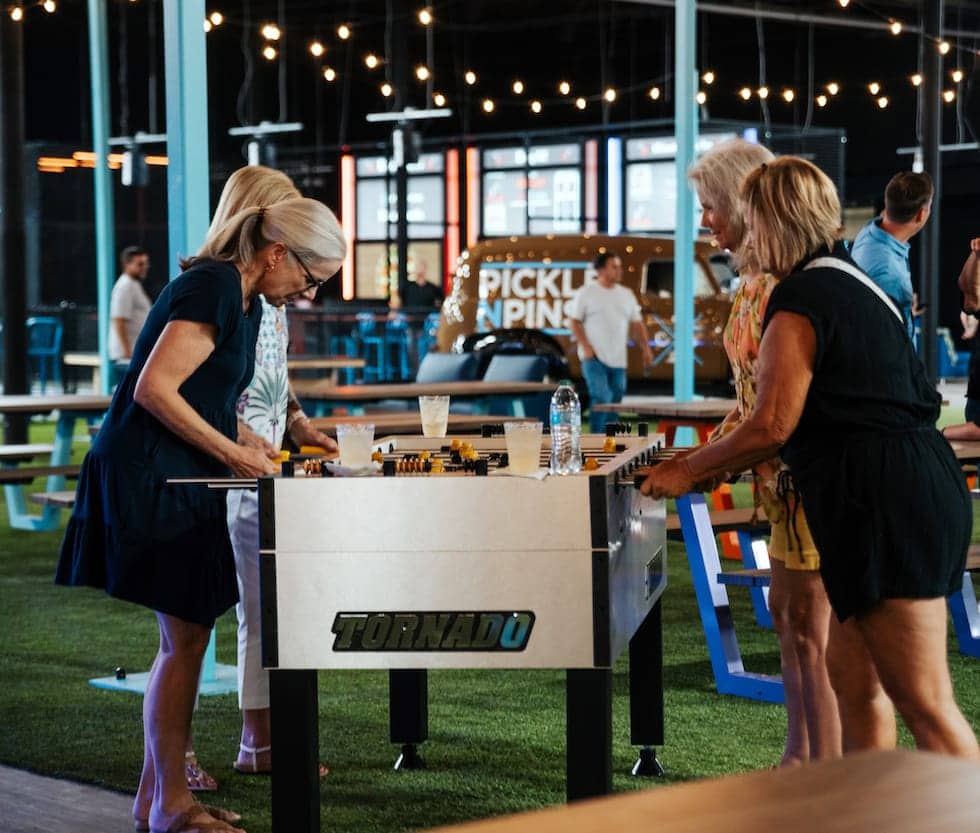 People playing foosball at Pickle-Pins