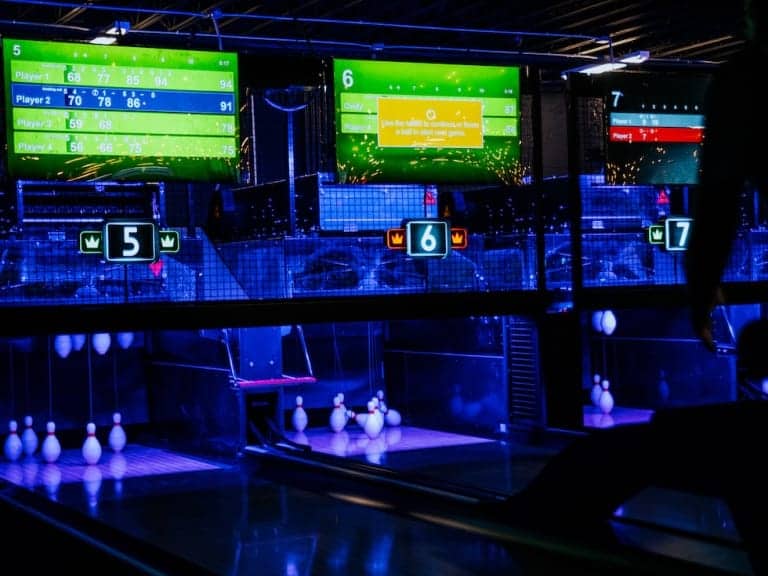 Bowling alley with multiple lanes and large screens at Pickle-Pins