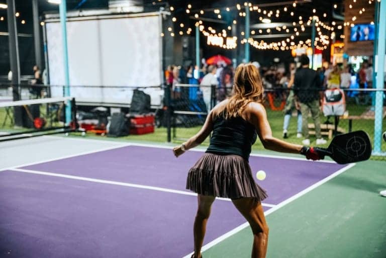 Outdoor pickleball in new Orleans with people socializing under string lights - Pickle-Pins