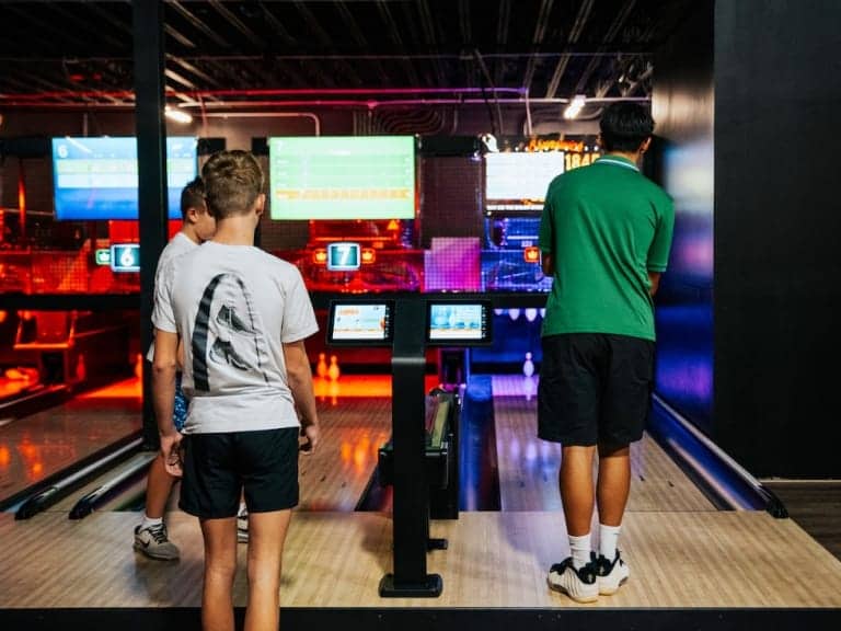 People playing in a modern bowling alley at Pickle-Pins