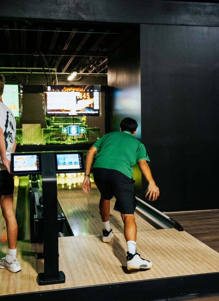 Man bowling in a modern, brightly lit bowling alley - Pickle-Pins