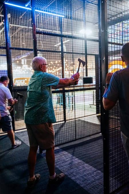 Man throwing axe in an axe throwing cage - Pickle-Pins