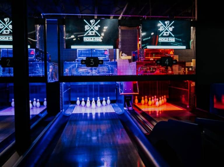 Modern bowling alley with glowing blue lanes at Pickle-Pins