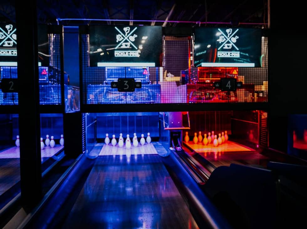 Modern bowling alley with glowing blue lanes at Pickle-Pins
