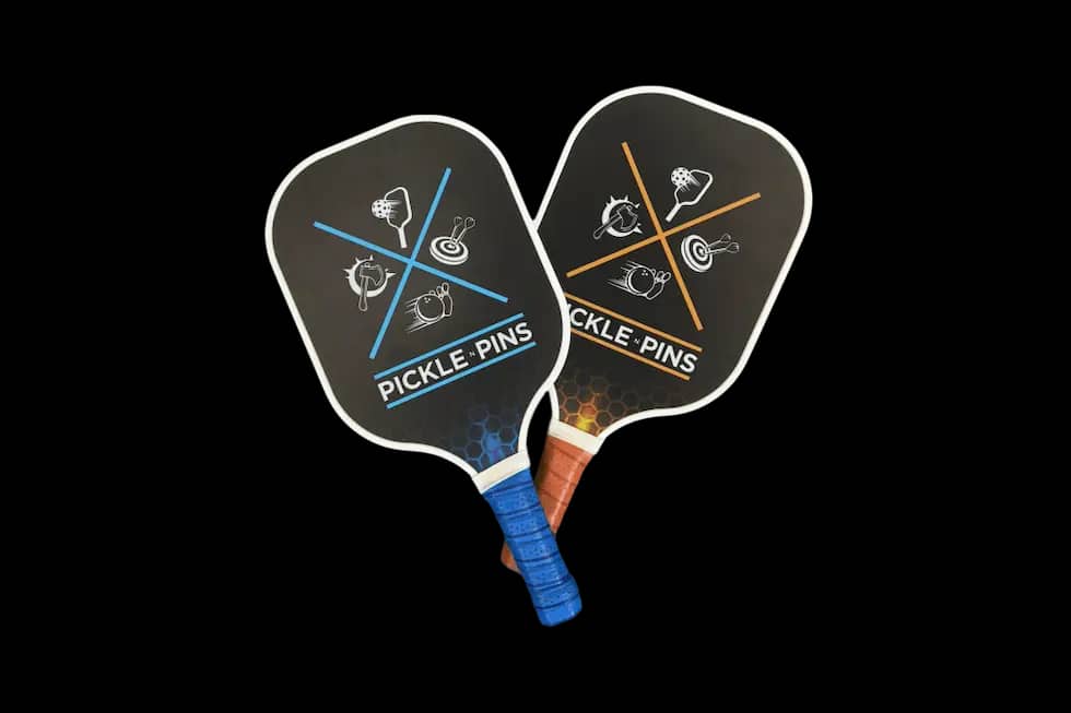 Two Pickle-Pins branded pickleball paddles on a white background