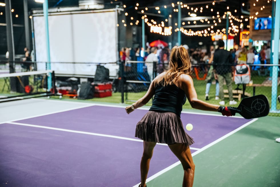 Outdoor pickleball in new Orleans with people socializing under string lights - Pickle-Pins Outdoor pickleball in new Orleans with people socializing under string lights - Pickle-Pins